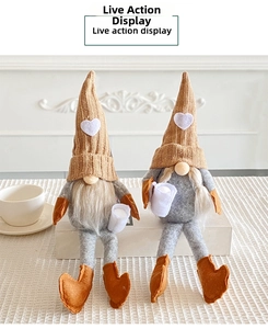 Detail of two Christmas gnomes with knit hats and heart accents on a white stand