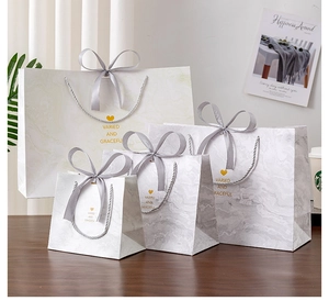 Detail of marble pattern gift bags with grey ribbon handles and gold heart printing