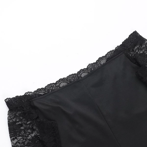 Gros plan sur la dentelle noire délicate et les finitions de la robe à épaules dénudées