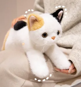 Close-up of calico plush cat with realistic fur, bionic whiskers, and vivid round eyes