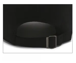 Detail view of the adjustable metal slider buckle on a black cotton baseball cap