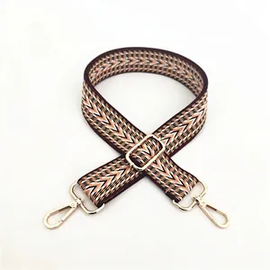 Close-up of ethnic geometric woven cotton bag strap with polished gold metal hardware