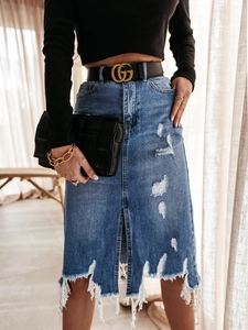 Detail of distressed blue denim midi skirt showing frayed hem and ripped texture