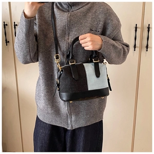 Detail of Boston bag showing denim patchwork and leather handles on model style