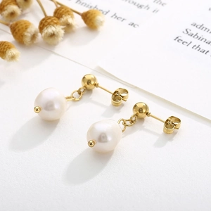Détail des boucles d'oreilles vintage avec perles et finition plaquée or 18 carats