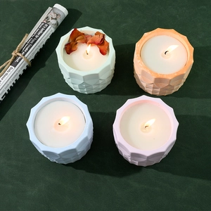 Set of 4 geometric textured candle jars in pastel colors with dried petals and flame