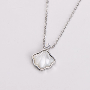 Detail shot of a silver shell pendant necklace with white mother-of-pearl and zircon
