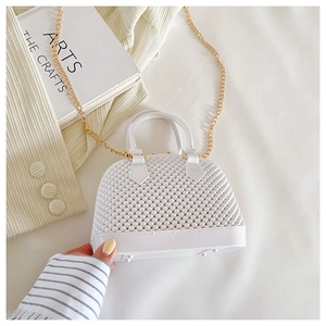 Detail of white PVC jelly shell bag with pearl texture and golden chain strap