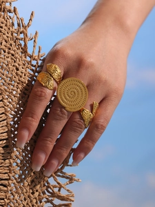 Exotic golden open bangle with a central spiral motif and leaf accents for summer vacation
