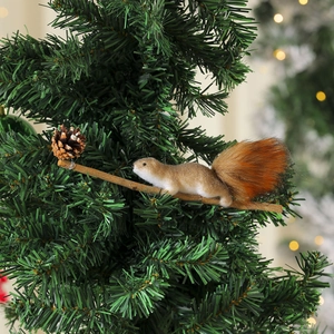 Close-up of a realistic squirrel ornament with natural pine cone on a Christmas tree