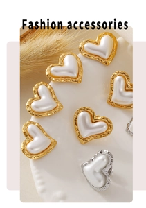 Detail of heart-shaped pearl stud earrings with hammered metal edge in gold and silver