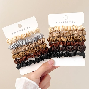 Set of 12 silk satin scrunchies in metallic earth tones shown on professional cards