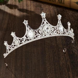Close-up of sparkling silver crystal crown headpiece for girls on a wooden surface
