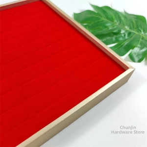 Close-up of a red velvet 100-slot jewelry display tray with elegant gold metal frame