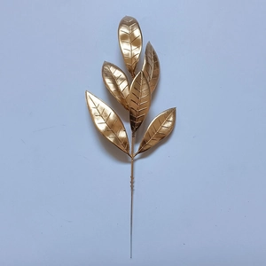Dettaglio di foglie di pino artificiali glitterate dorate per decorazioni natalizie