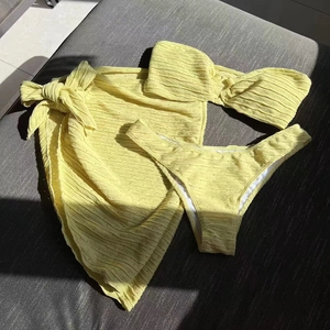 Three-piece pale yellow bikini set with bandeau top, briefs and textured wrap skirt