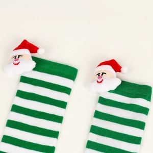 Detail of green and white striped Christmas socks with 3D plush Santa Claus decoration