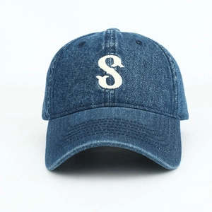 Close-up of a dark blue denim baseball cap featuring white embroidered S letter detail