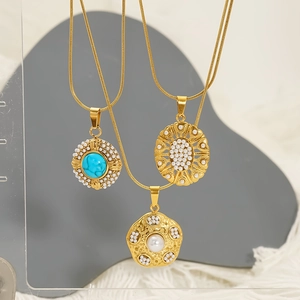 Three gold stainless steel necklaces with turquoise and pearls on an elegant display
