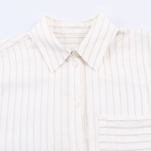 Close-up detail of white striped shirt featuring refined collar and button textures