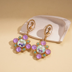 Detail view of vintage bohemian drop earrings with purple crystals and enamel relief