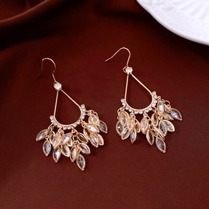 Detailed macro of 18k gold plated water drop earrings with marquise cut crystal tassels