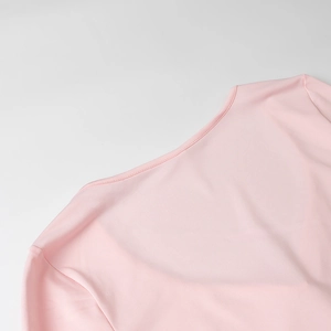 Detailed view of pink knitted dress neckline with smooth texture and neat stitching