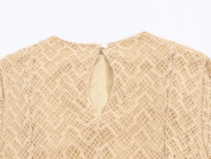 Detail of beige lace dress with keyhole back and white button closure on floral fabric