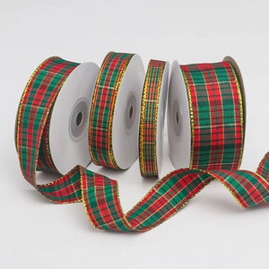 Detail showing four rolls of red and green plaid Christmas ribbon with gold glitter edges