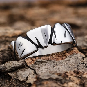 Rugged silver stainless steel jagged geometric ring on textured wood bark background