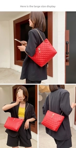 Detail showing the large red quilted tote bag with pearl pendant and gold chain strap