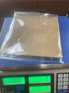 Weight measurement of a brown kraft paper DIY scrapbook album showing 208g on scale