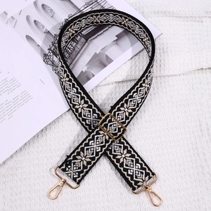 Close-up of ethnic embroidered bag strap in black and grey with gold hardware