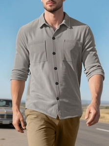 Detail of light gray corduroy shirt featuring double chest pockets and workwear design