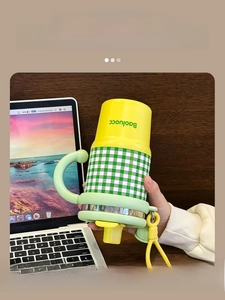 Detail of leak-proof silicone seal and green handle on plaid insulated coffee cup
