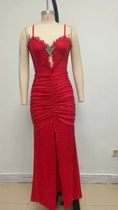 Detail of red sequined dress featuring heart neckline with lace and silver brooch