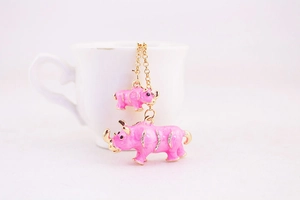 Detail of pink rhinoceros keychain featuring golden edges and sparkling rhinestones