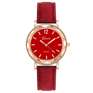 Close-up of red dial quartz watch with faceted rose gold case and suede strap