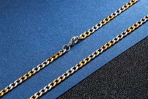 Close-up of two-tone gold and silver curb chain necklace with a secure lobster clasp