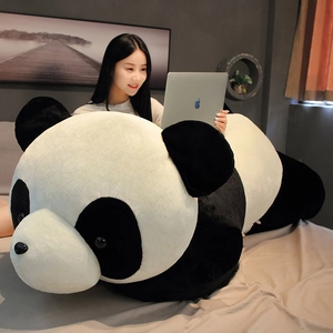 Détail d'une housse de coussin géante panda en peluche sur un lit douillet