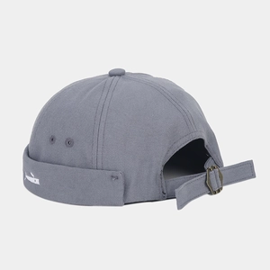 Close-up of grey docker hat featuring white whale embroidery and adjustable metal buckle