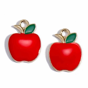 Macro detail of two red apple alloy charms with gold frames and green leaves for DIY jewelry