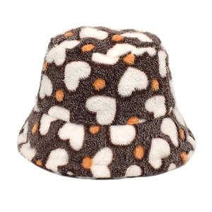 Détail d'un chapeau bob en peluche avec motifs cœurs et pois en marron, blanc et orange