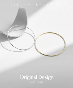 Detailed close-up of polished silver and gold minimalist bangles with geometric shadows