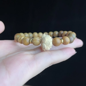 Détail macro d'une perle lotus en bois de santal sculptée et de perles de prière