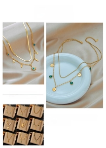 Detail of layered gold necklaces featuring sun, star and green turquoise pendants