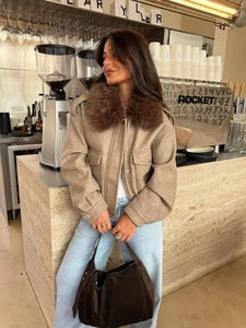 Detailed view of women's khaki jacket with plush faux fur collar in casual street style