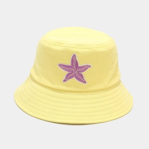 Close-up of yellow cotton bucket hat with purple starfish embroidery and fine stitching