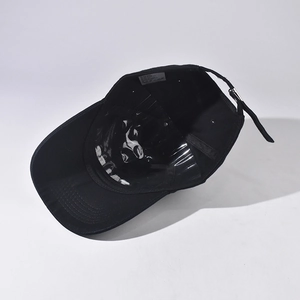 Detailed inner view of black cotton baseball cap showing metal buckle and care label