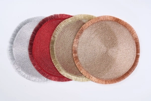 Detailed view of woven round placemats with fringe in silver, gold, red and rose gold